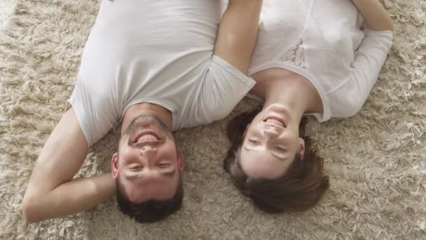 Man and Woman Laying on Floor Looking Up and Laughing. Concept of Happiness and Tenderness. - Πλάνα, βίντεο