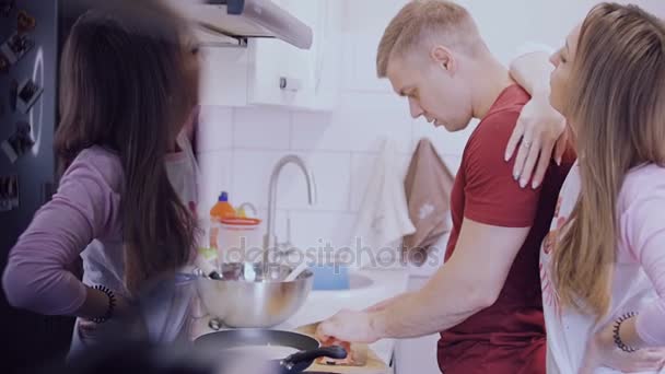 若いカップルは台所で魚とパンケーキを調理します。. - 映像、動画