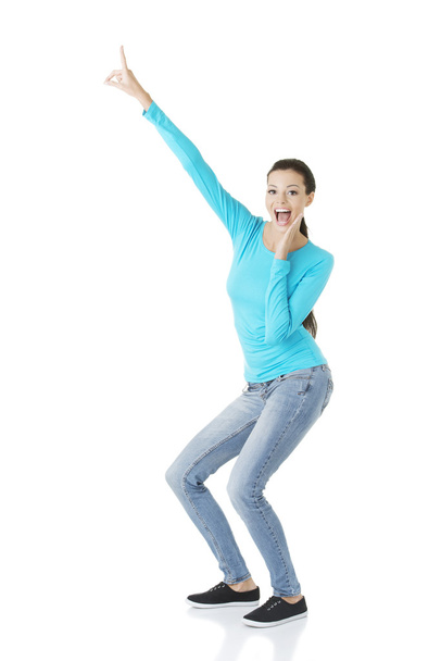 Excited young woman pointing on copy space - Foto, imagen