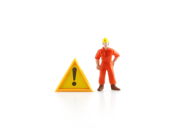 Waarschuwing teken in aanbouw met miniatuur figuur labo - Foto, afbeelding