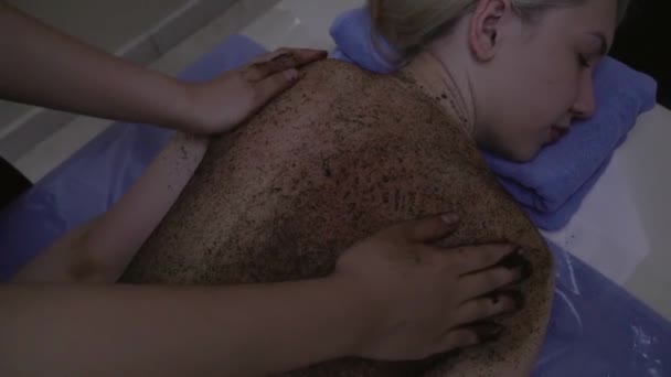 Girl on the procedure of coffee peeling in spa salon stock footage video - Filmagem, Vídeo
