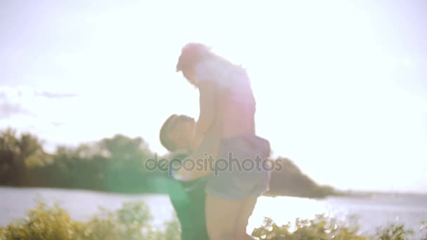 Mladý muž vyvolává mladou ženu v náručí. - Záběry, video