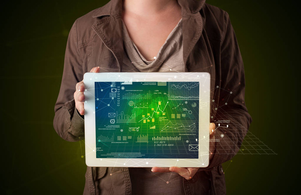 Woman holding tablet with business plan graphics - Foto, afbeelding