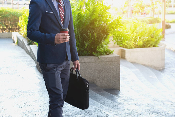 picture of a young business man walking forward with a briefcase - Valokuva, kuva