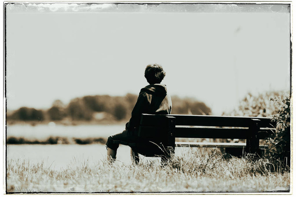 mulher sentada no banco olhando na água
 - Foto, Imagem