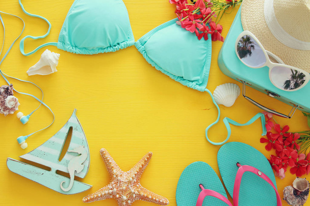 fashion female swimsuit bikini on yellow wooden background. Summer beach vacation concept - Фото, изображение