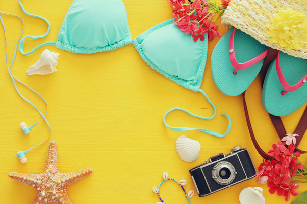 fashion female swimsuit bikini on yellow wooden background. Summer beach vacation concept - Zdjęcie, obraz
