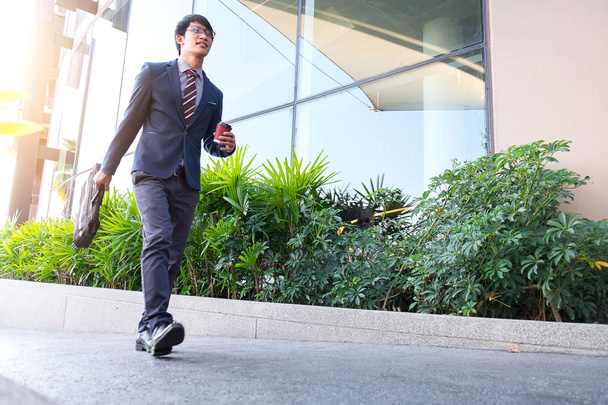 picture of a young business man walking forward with a briefcase - Foto, imagen
