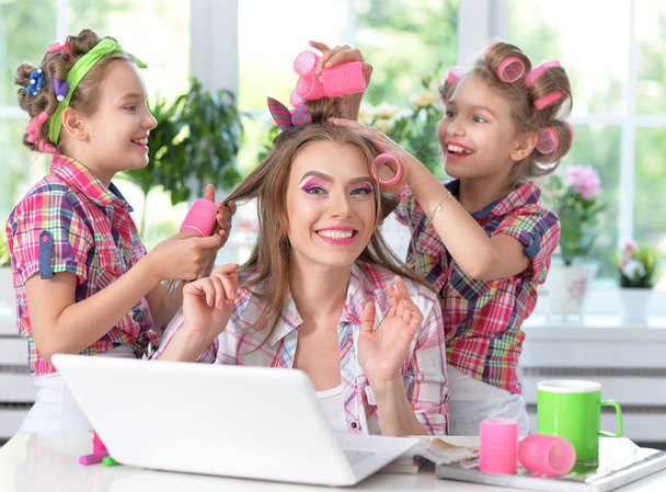 mother and daughters making hairstyles - Фото, зображення