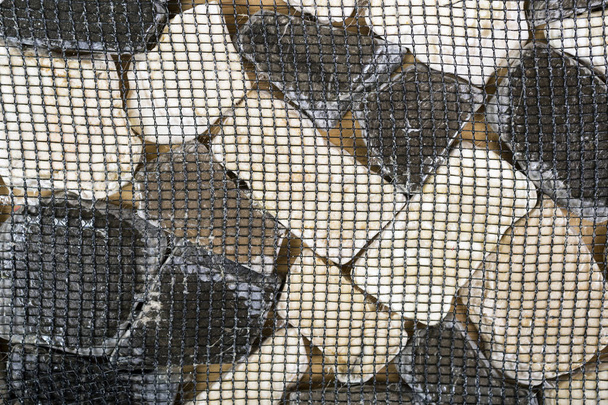 Tegel uit dolomiet stenen op een raster - Foto, afbeelding
