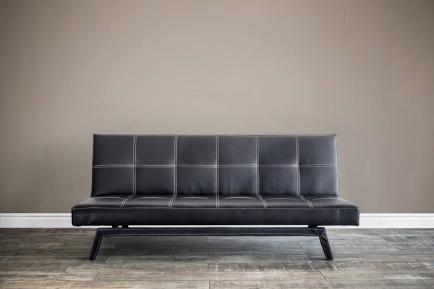 Front view of black leather sofa. - Фото, изображение