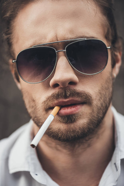 Stylish young man smoking - 写真・画像