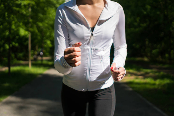 Woman jogging outdoors. Close-up. - Фото, изображение
