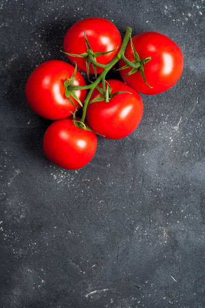 Tomatoes on dark concrete background. Vegetables for cooking and healthy eating - Foto, imagen
