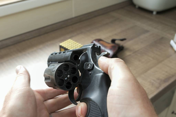 Az ember egy lőszer revolver újratöltése - Fotó, kép