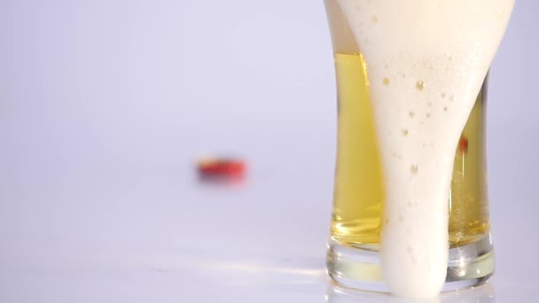 Glass of beer emptying on white background. close up - Materiaali, video