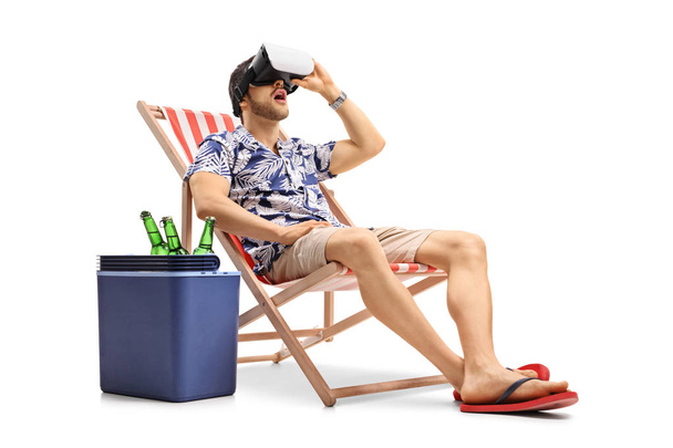 Tourist using a VR headset and sitting in a deck chair - 写真・画像
