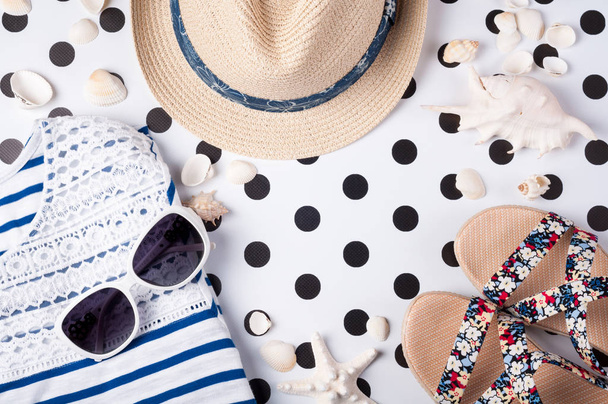 Kesänaisten asusteet: aurinkolasit, hattu, sandaalit, luovalla pohjalla oleva paita. Lomat ja matka konsepti ylhäältä
 - Valokuva, kuva
