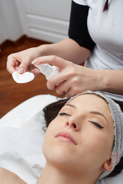  Relaxing beautiful woman having a massage for her skin on a face in beauty salon - Foto, Imagem