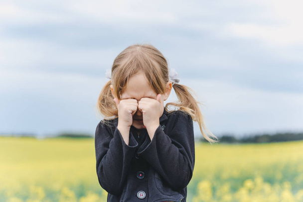 little cute caucasian girl making faces in field - Fotografie, Obrázek