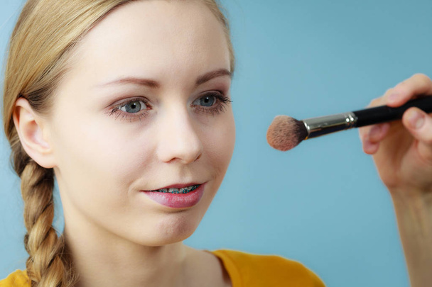 Makeup artist applying with brush rouge on female check - Foto, Imagen
