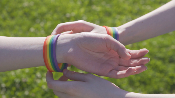 βάζοντας σε ένα βραχιόλι με σύμβολα ΛΟΑΤ - Πλάνα, βίντεο