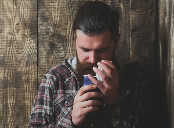 Bearded brutal man opening blue plastic cup - Photo, Image