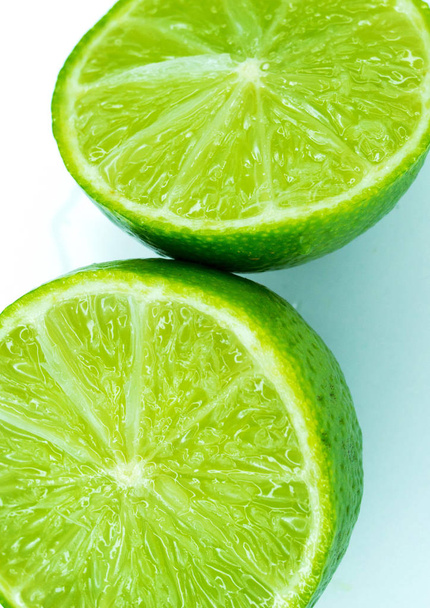 Sliced ripe juicy lime close-up on white - Photo, Image