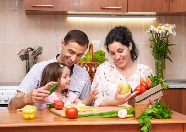 boldog család, a gyermek otthoni konyha belső, friss gyümölcsök és zöldségek, terhes nő, egészséges élelmiszer koncepció - Fotó, kép