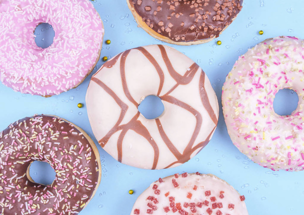 Colorful donuts on blue background. - Photo, Image