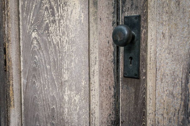 Ρουστίκ vintage πόρτα κομβίο σε ξύλο αντίκα πόρτα. Πόμολο πόρτας και κλειδαρότρυπα από ορείχαλκο για την παλιά ξύλινη πόρτα. Πόμολο πόρτας για το φόντο. - Φωτογραφία, εικόνα