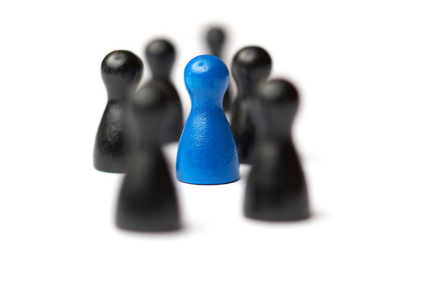 Blue figure in the middle of a group. Other figures blurred. Business concept for leadership, teamwork or groups. Isolated on white background. - Photo, Image