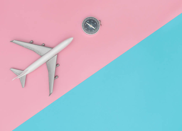 Avion jouet avec boussole pour un concept de voyage chic et coloré, avec broche et espace de copie pastel bleu
. - Photo, image