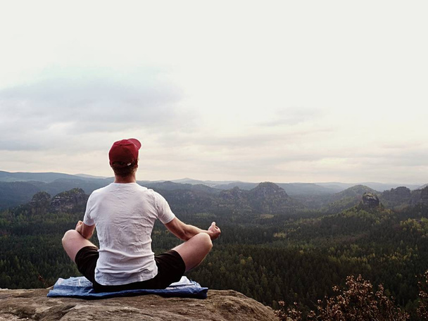 Yoga praticato in cima alla montagna con vista aerea sulla valle della montagna. Alto sportivo che pratica yoga
 - Foto, immagini
