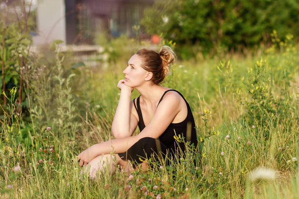 Young woman sitting on grass - Foto, Bild
