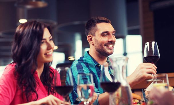 friends clinking glasses of wine at restaurant - Foto, imagen