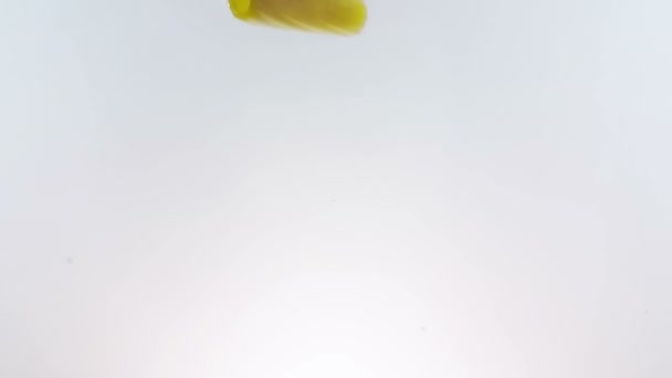salpicadura de pasta de macarrones cayendo en agua hervida, tiro en cámara lenta sobre fondo blanco, nutrición italiana y cuidado de la salud
  - Metraje, vídeo
