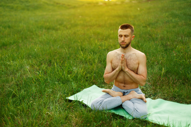 Man doing yoga in the park on nature. Meditation - Фото, зображення
