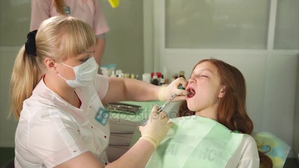 Női fogorvos fogászati szekrényben beteg lány csinál érzéstelenítő injekció. - Felvétel, videó