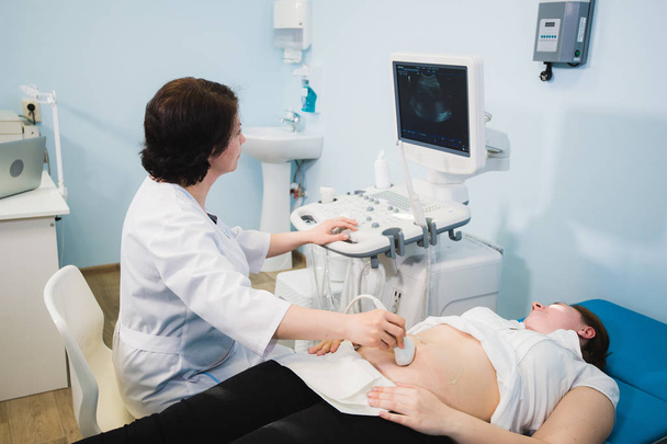 Zwangere vrouw ontvangt ultrasone behandeling in het ziekenhuis - Foto, afbeelding