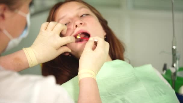 close up tiro das mãos das enfermeiras, que anestesiam as gengivas do adolescente
 - Filmagem, Vídeo