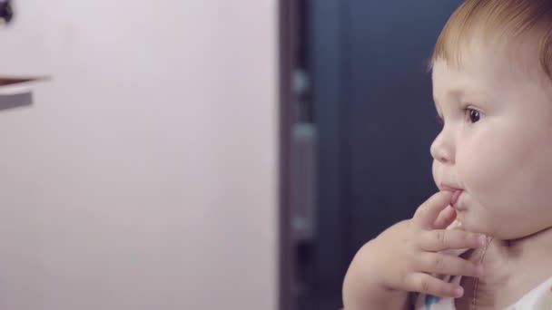 Slow Mo: Close-up van portret van schattige kleine jongen likt zijn vingers, op zoek zorgvuldig rechtdoor - Video