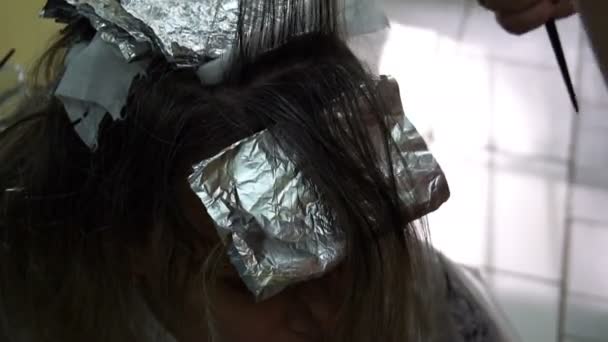 kobieta w fryzjer, fryzjer farbuje włosy - Materiał filmowy, wideo
