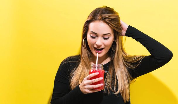 Happy young woman drinking smoothie - Zdjęcie, obraz