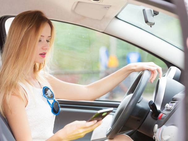 Woman using phone while driving her car - Фото, зображення