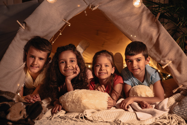 monikansalliset lapset lepäävät teltassa
 - Valokuva, kuva