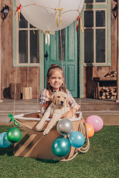 meisje met puppy in lucht ballon vak - Foto, afbeelding