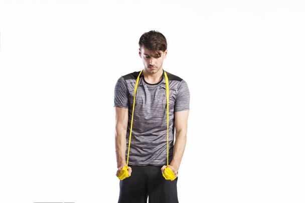 Handsome fitness man working out with rubber band, studio shot. - Fotó, kép