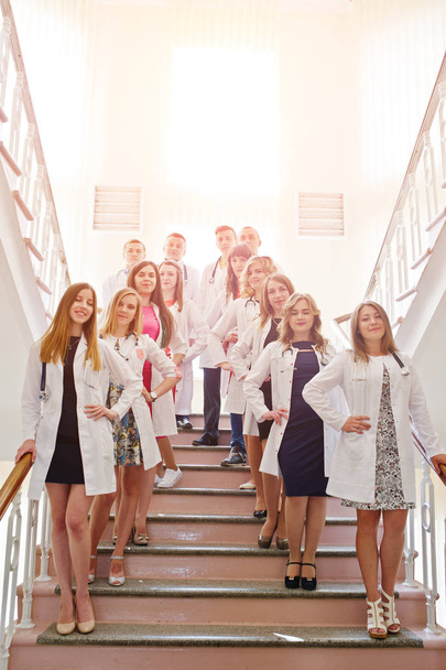 Group of young doctors in white coats posing in the hospital. - Foto, Bild