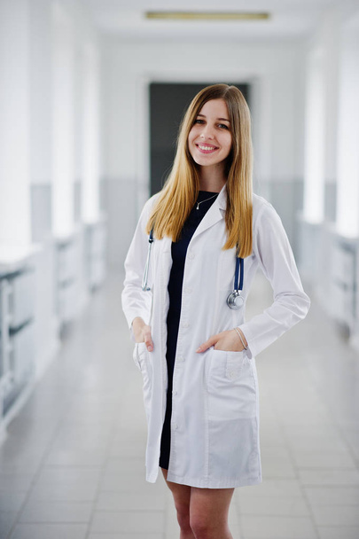 Portrait of a young attractive doctor in white coat with stethos - Foto, afbeelding